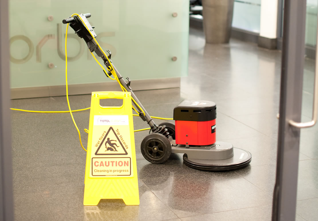 professional hard floor waxing equipment with a caution cleaning in progress sign