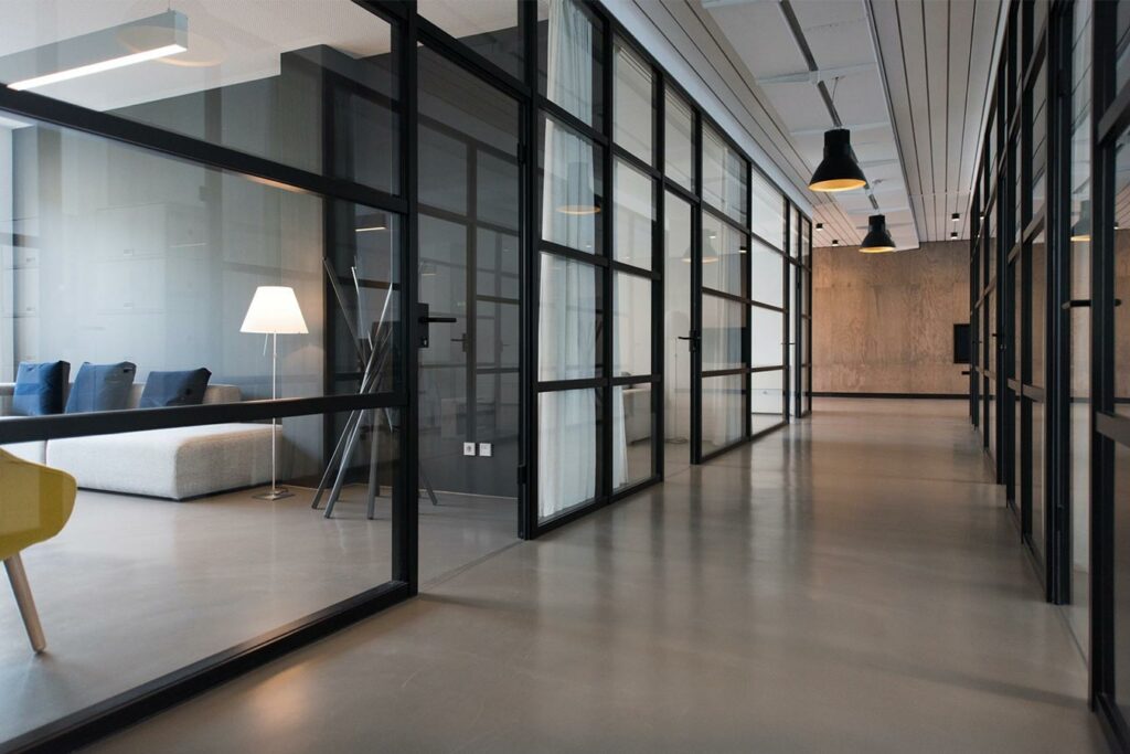 clean office hallway with sofa and lamp in the nearest room