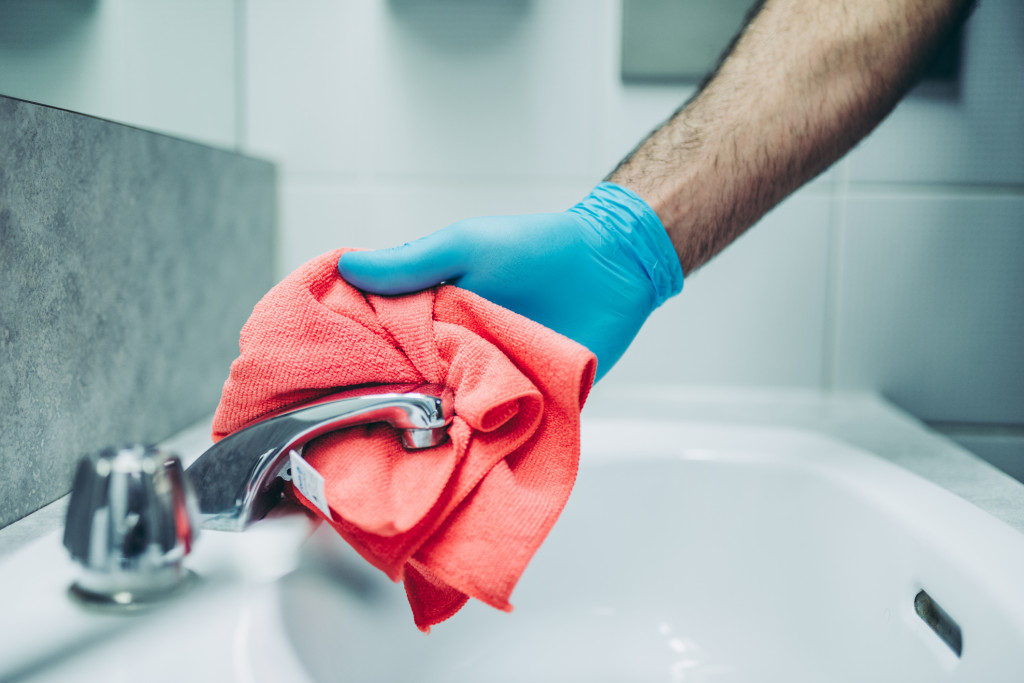Hands of a janitor cleaning the bathroom
